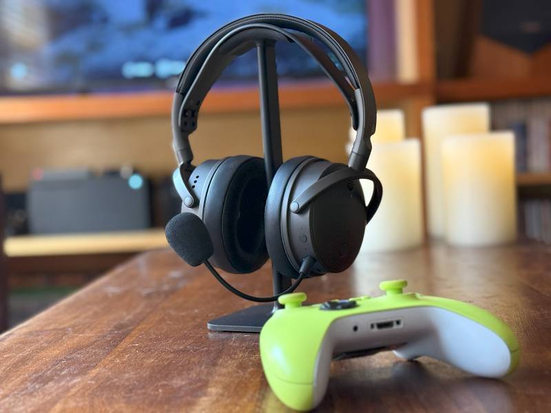 Audeze Maxwell Wireless Gaming Headset Review: Audiophile-Grade Sound in a Top-Tier Gaming Headset 1 Audeze Maxwell Wireless Gaming Headset on stand with a gaming controllersitting on the table in front of it.