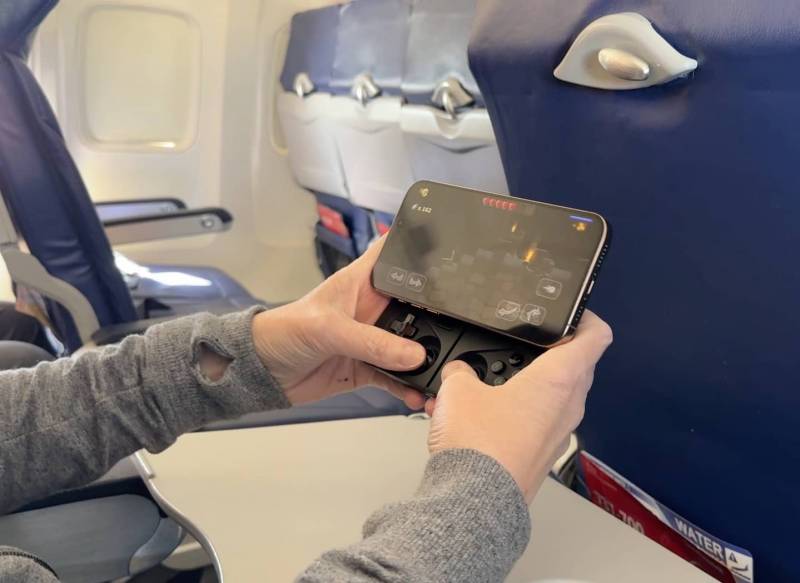 The Travel Gadgets I Took to Sanibel Island — and What I’d Pack Again 12 Holding MCON with iPhone in plane